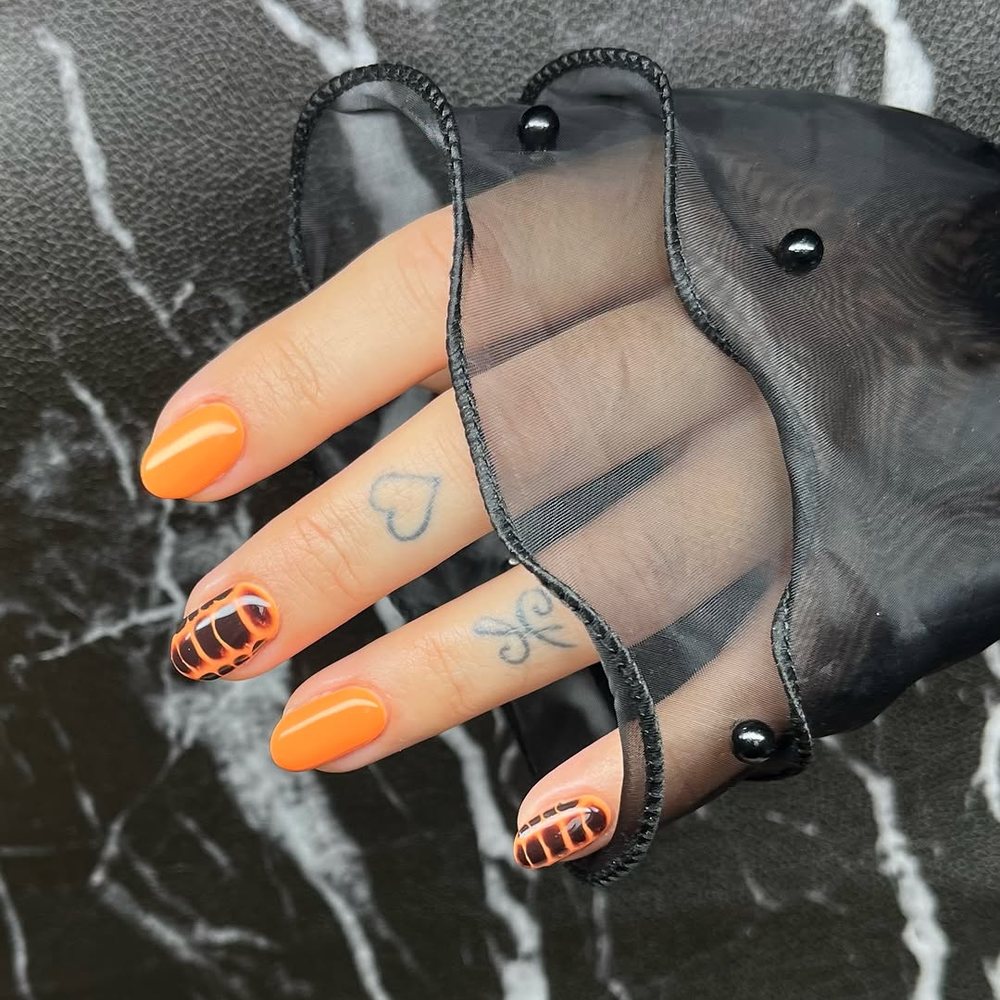 Oranje nagels met zwarte lijntjes als nailart, door Salon LaZoa